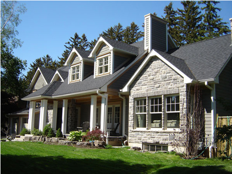 Two-story stone and siding home with a new dark shingle roof