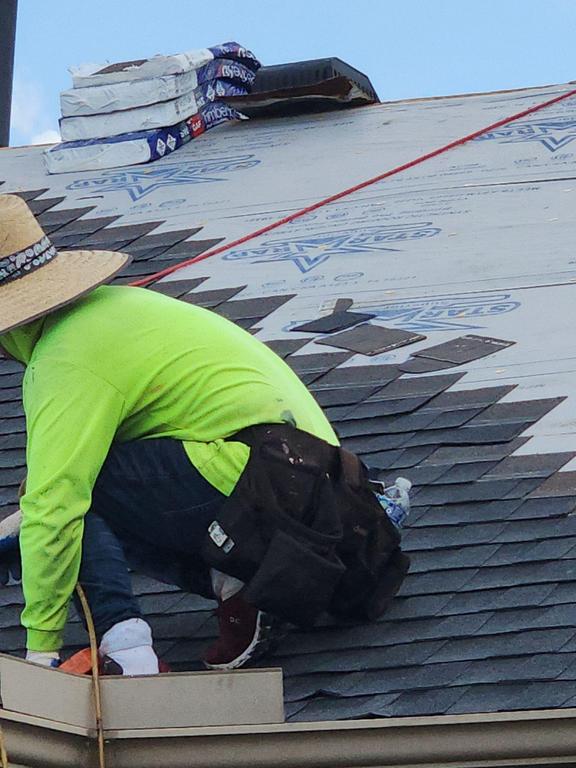Talton Roofing crew member installing architectural shingles over synthetic underlayment