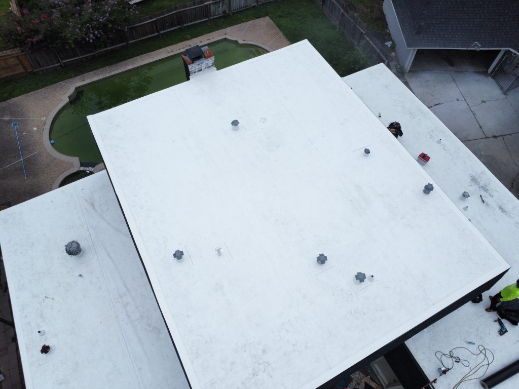 White flat roof coating on a low-slope residential roof
