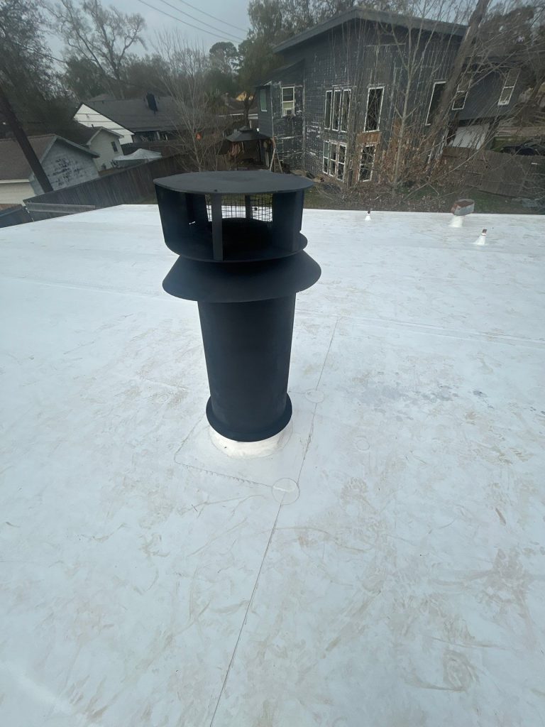 Roof vent pipe flashed into a white flat roof