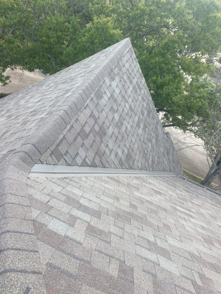 Architectural shingle roof ridge and step flashing on a home