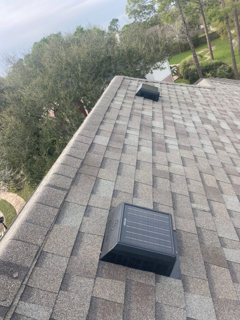 New architectural shingle roof with box vent on a wooded lot