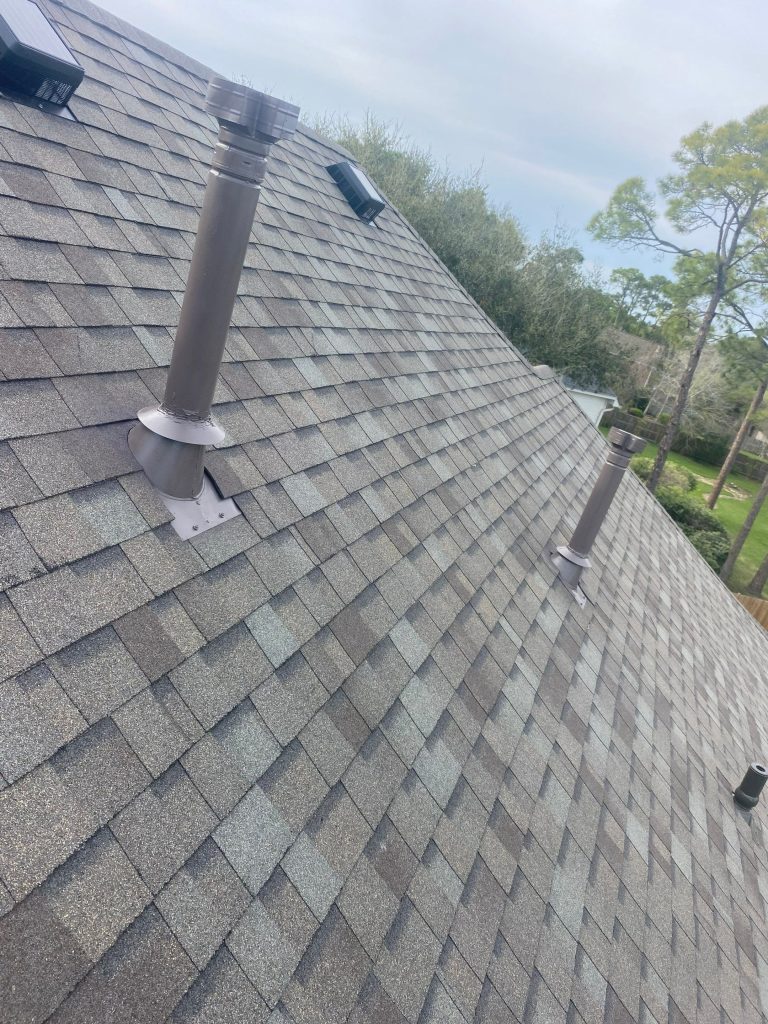 Close-up of new architectural shingles with roof vent pipes