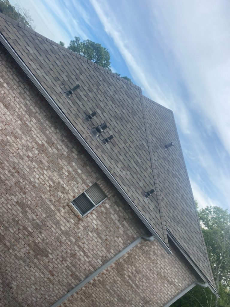 Steep architectural shingle roof on a two-story brick home