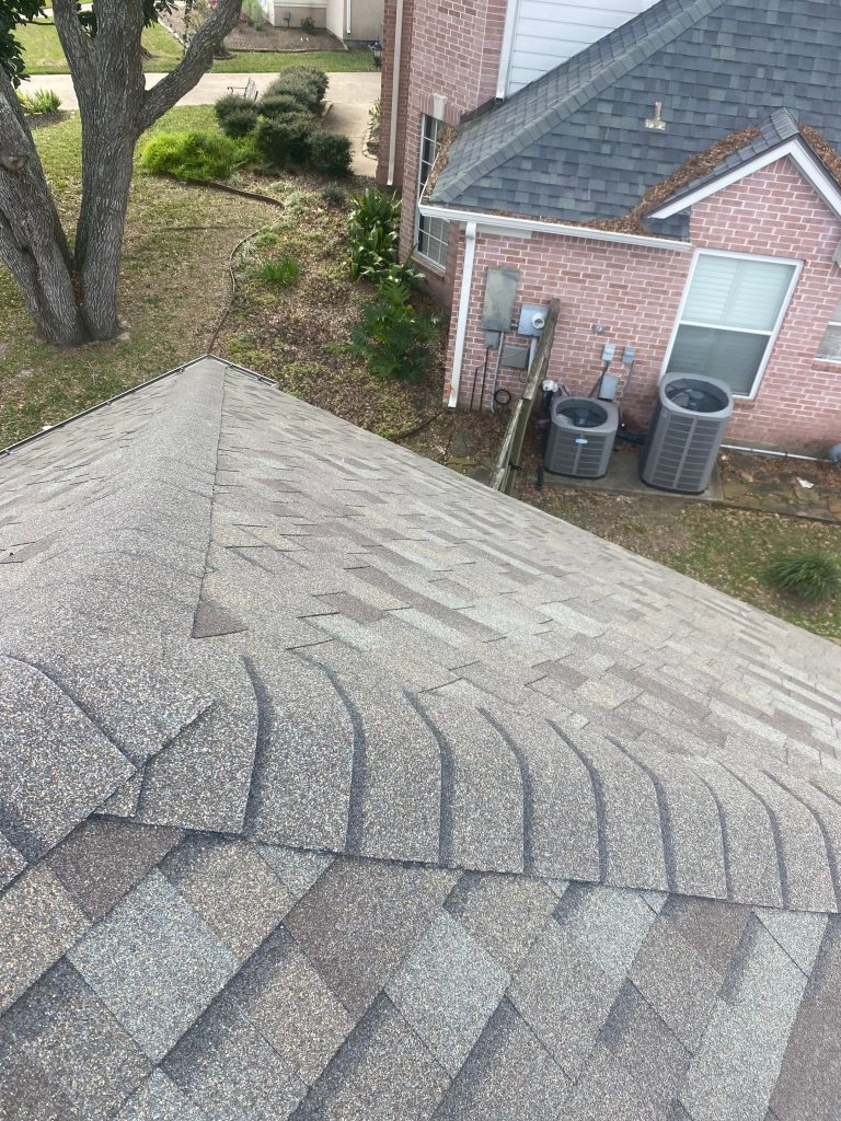 New architectural shingle roof ridge on a brick home