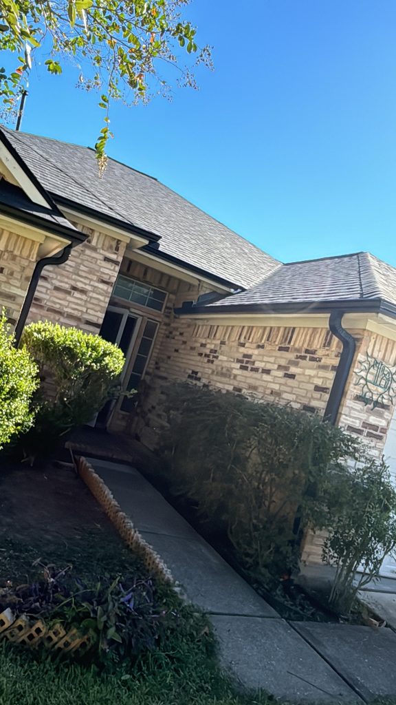 Brick home with a new shingle roof and landscaped front walkway
