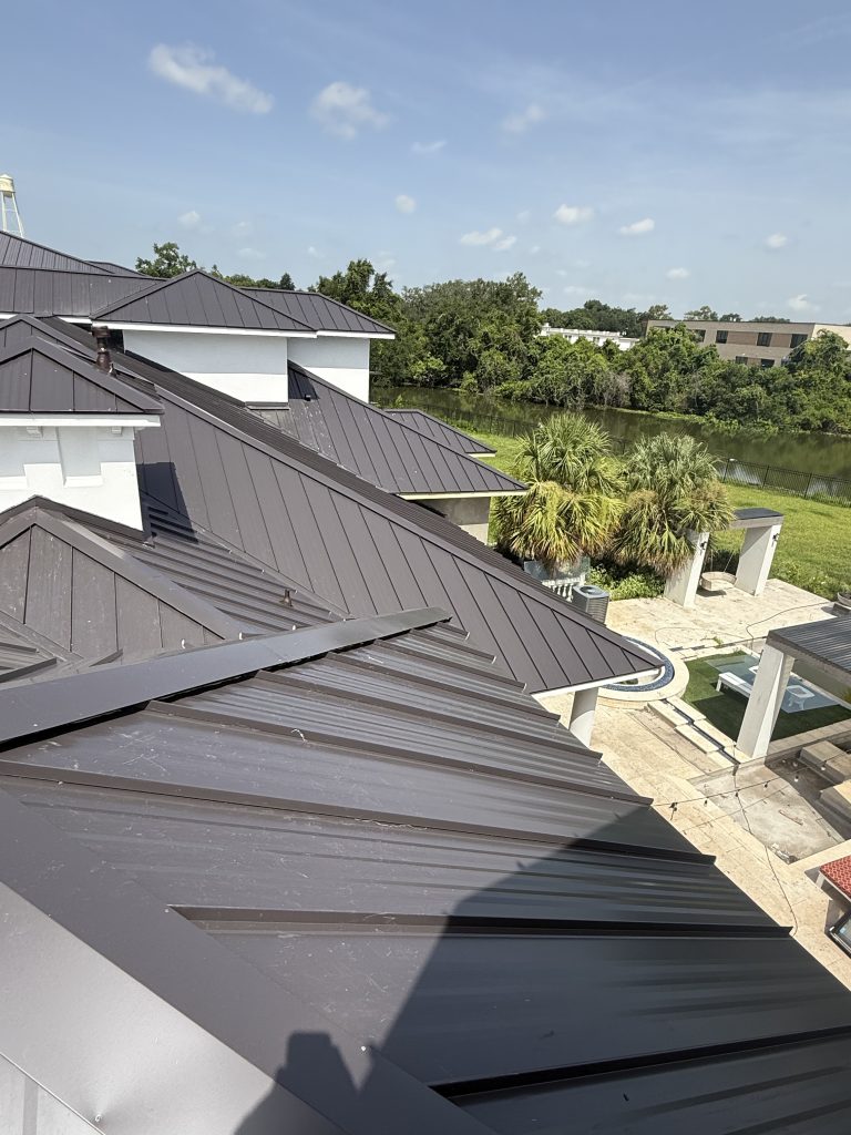 Dark standing seam metal roof on a waterfront home