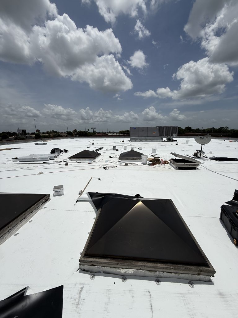 Finished white flat roof with skylights on a commercial building