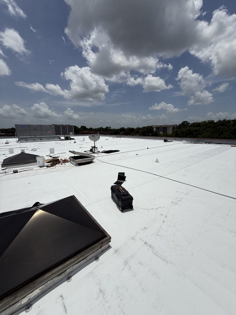 White TPO flat roof on a commercial building with skylight and roof vents