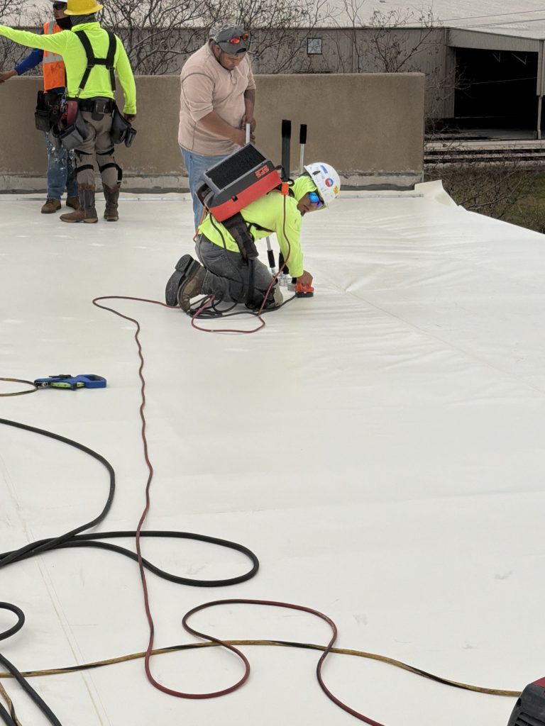 Talton crew welding seams on a commercial flat roof membrane