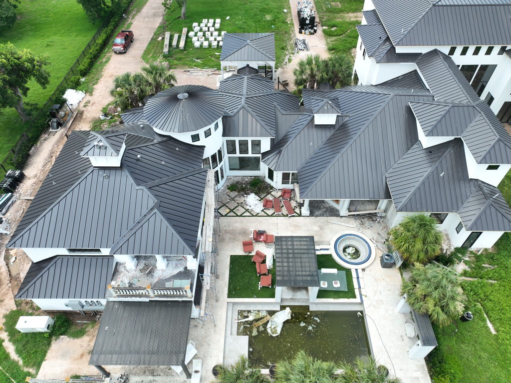 Aerial view of a large estate with a new dark standing seam metal roof