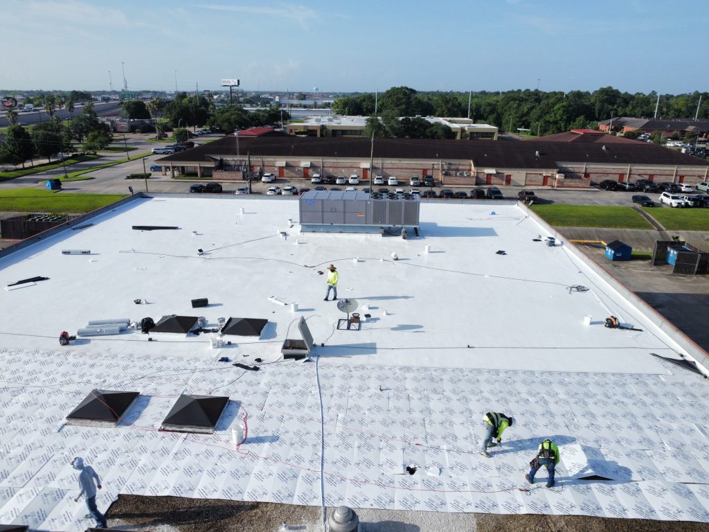 Talton crew installing a white flat roof on a large commercial building